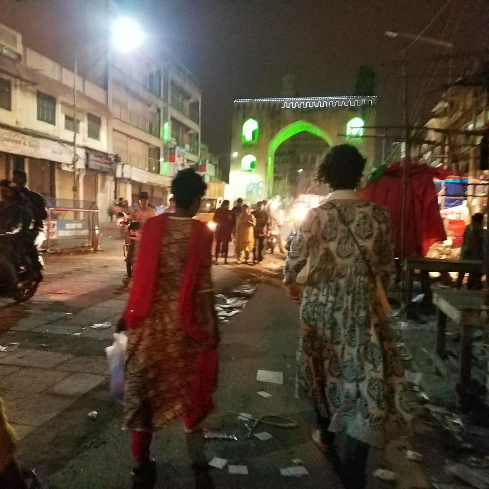 Women walking through the night bazaar toward the Charminar gate